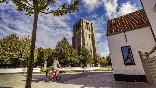 the church tower on Damme's town square with a cyclist